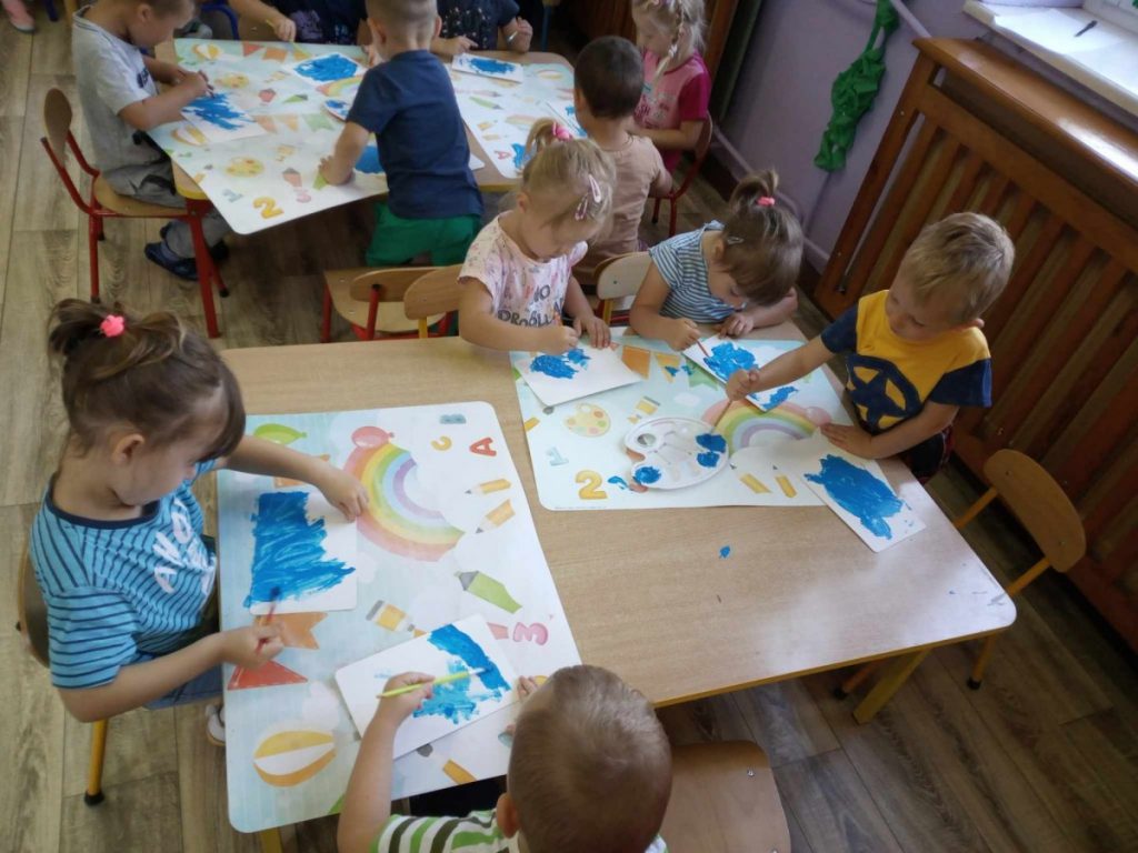 Na zdjęciu dzieci wykonują pierwszą pracę plastyczną- malują farbami morze