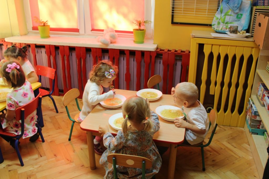 Trójka dzieci przy stoliku zjada obiadek