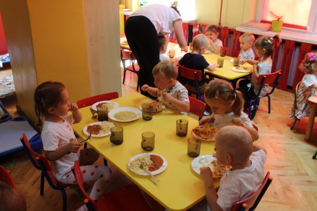 Dzieci przy stoliku w oczekiwaniu na obiadek