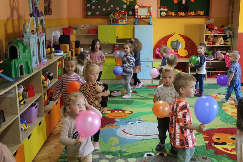 Zabawy ruchowe z balonikami na sali przedszkolnej