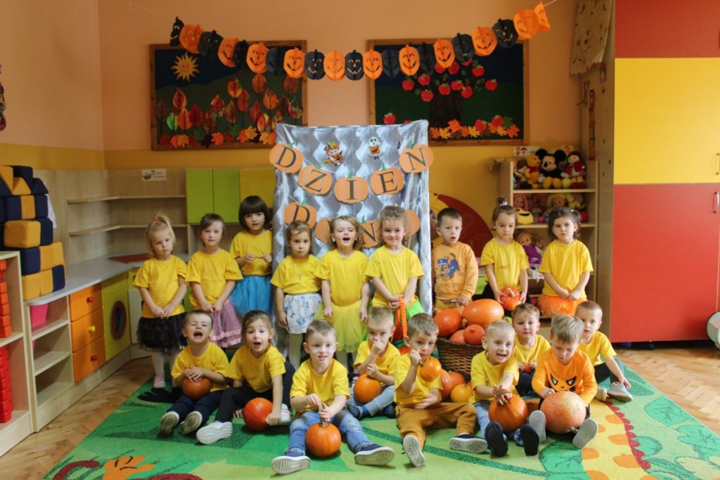 grupa dzieci w żółtych podkoszulkach pozuje do zdjęcia grupowego