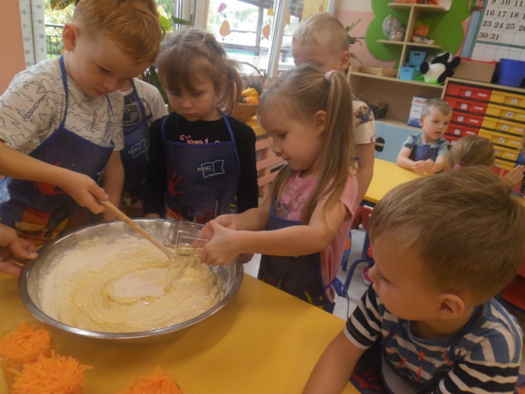 Na zdjęciu dzieci wykonują ciasto z dyni