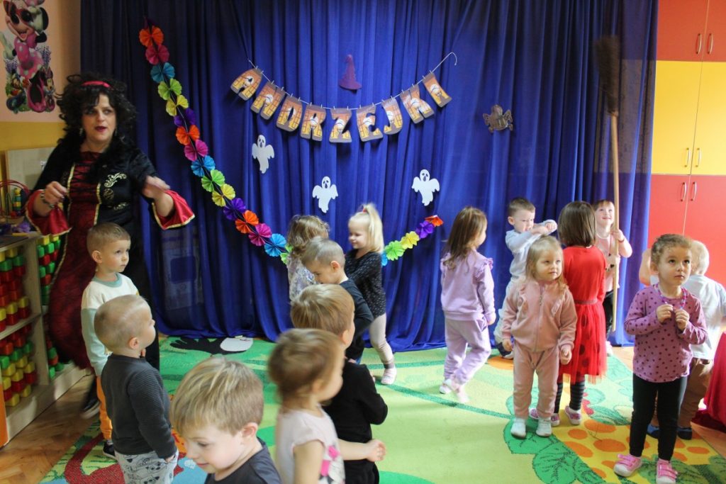 Zabawy dzieci na dywanie w tle dekoracja z napisem Andrzejki