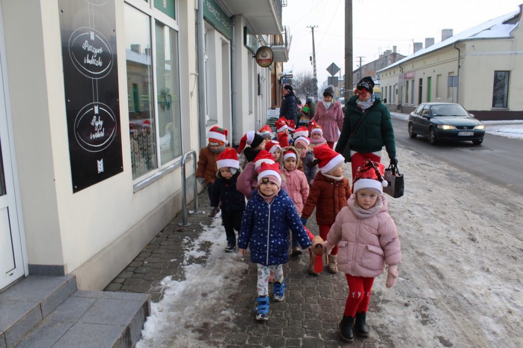 dzieci w parach w czerwonych czapkach na spacerze