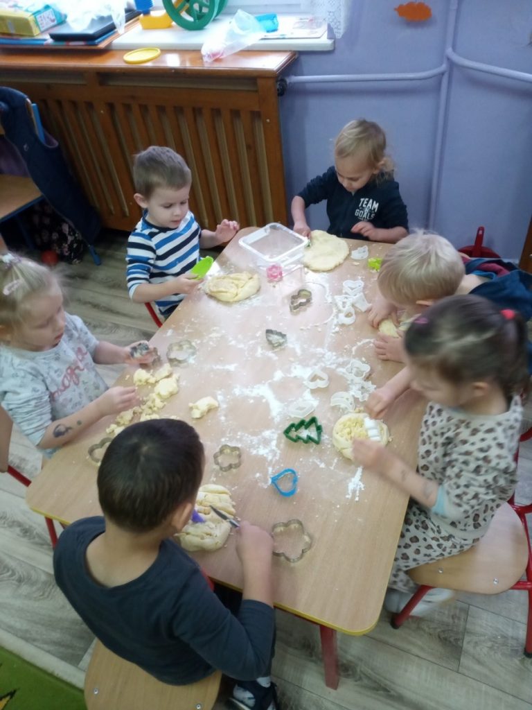 Na zdjęciu są dzieci przy stoliku, tworzą masę dyniową.