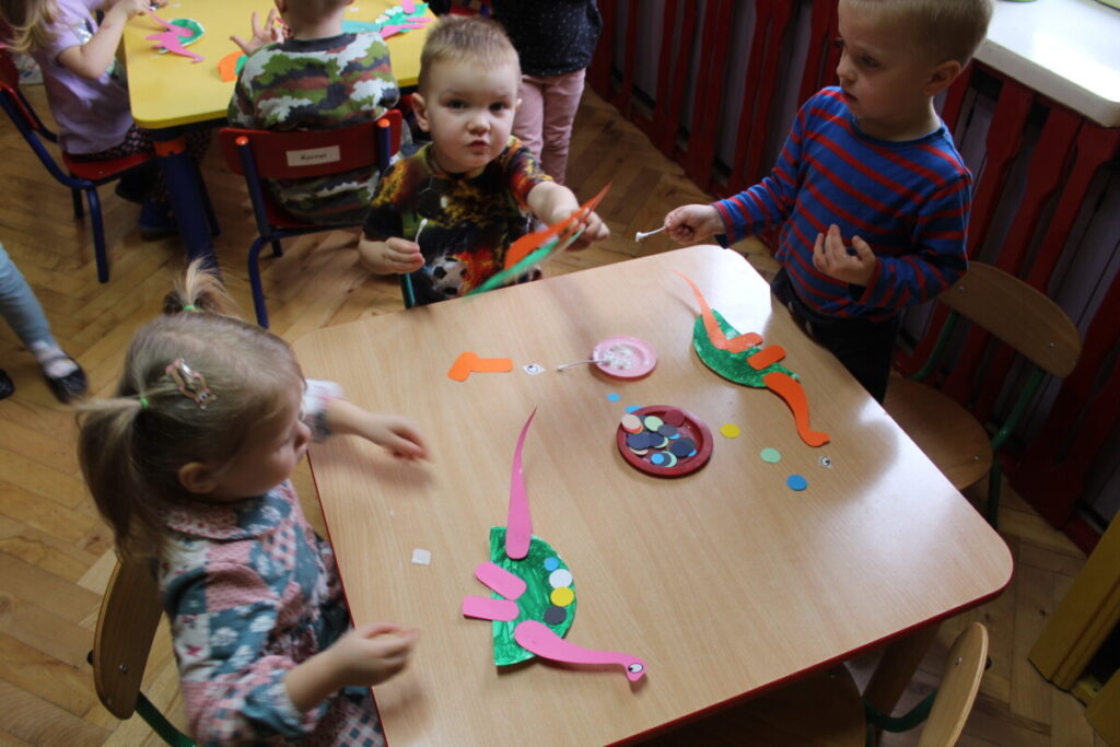 Dzieci przy stoliku wykleją dinozaura